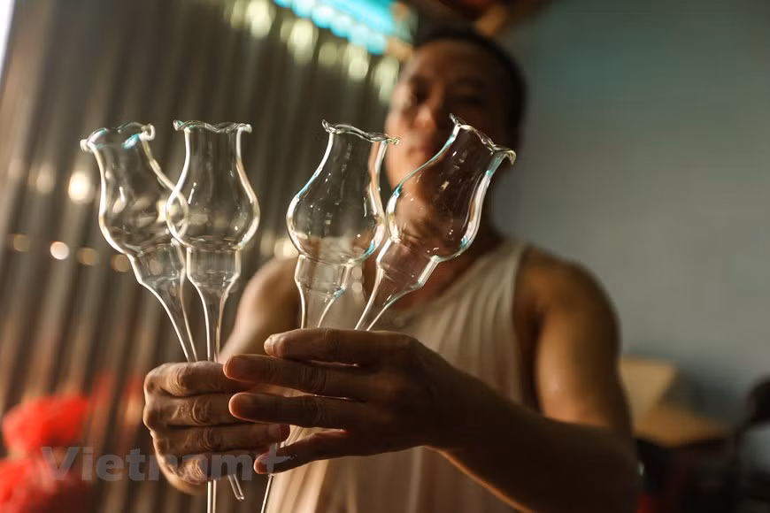 Aunque también puede ser producido por el ser humano, el vidrio es un material inorgánico duro, frágil, transparente y amorfo que se encuentra en la naturaleza. El vidrio artificial se usa para hacer ventanas, lentes, botellas y una gran variedad de productos. Dicho material constituye un tipo de cerámica amorfa. El vidrio se obtiene a unos 1.500 °C a partir de arena de sílice, carbonato de sodio y caliza. A partir de 1960, el soplado de vidrio ha sido la principal ocupación de la mayoría de los residentes de la comuna de Thong Nhat. La aldea de Giap Long deviene la zona más desarrollada en este oficio en la comuna, donde se concentran muchos trabajadores hábiles. (Fuente:Vietnam+) 