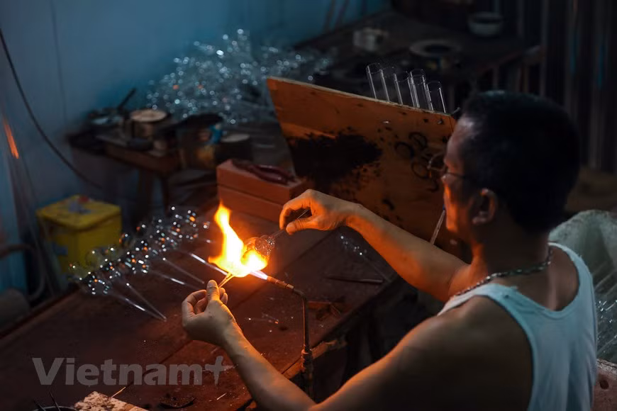 Desde 1960, el soplado de vidrio ha sido la principal ocupación de la mayoría de los residentes de la comuna de Thong Nhat. La aldea de Giap Long resalta como la zona más desarrollada en este oficio en la comuna, donde se concentran muchos trabajadores hábiles, quienes pueden elaborar productos complicados y delicados de vidrio. Le Xuan Tien, con más de dos décadas de experiencia en esta labor, contó que hace diez años, casi toda la comuna se dedicaba a este trabajo. Los aldeanos podían hacer cualquier producto doméstico común, como botellas, vasos, o tapones de termos. Comentó que para confeccionar artículos de calidad, los sopladores de vidrio deben conocer muy bien las características de este material. (Fuente:Vietnam+) 