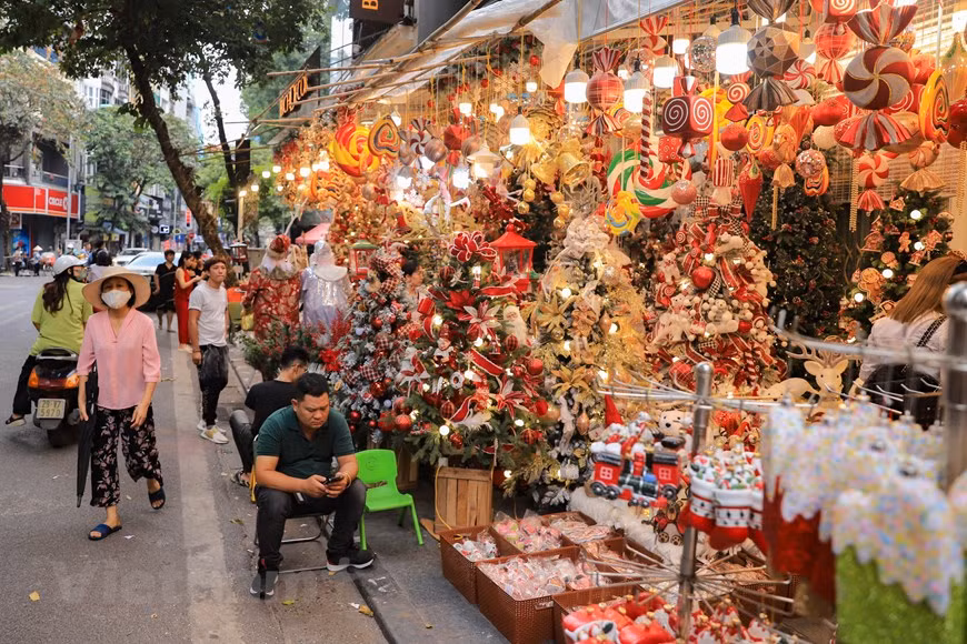 A lo largo de la bulliciosa calle de Hang Ma, en el casco antiguo de esta capital milenaria, pueden apreciarse los coloridos adornos. Una serie de artículos decorativos para celebrar la Navidad están a la venta para los residentes de Hanoi, sean cristianos o no, y estos objetos alegran los hogares en el frio invierno. La calle se ha convertido en un lugar instantáneo para los jóvenes de Hanoi en la temporada festiva.A los vietnamitas les encanta decorar la ciudad con belenes gigantes llenos de luces LED de colores, árboles de Navidad y muñecos de nieve hechos con goma de espuma en cada esquina. (Fuente: Vietnam+)