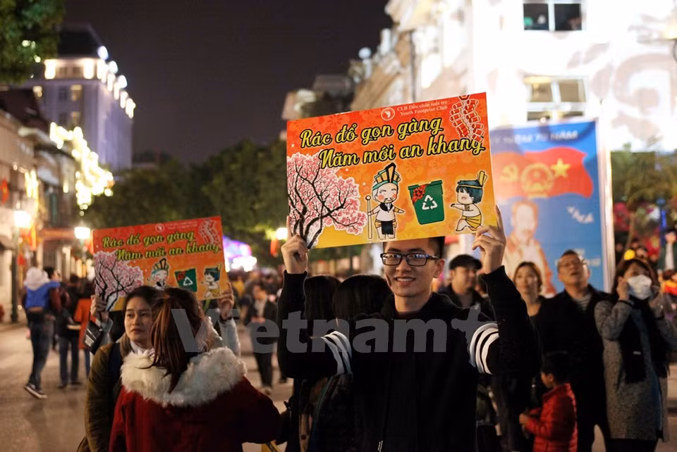 Estudiantes con pancartas que llaman a la gente no tirar basuras en la calle (Fuente: VNA)