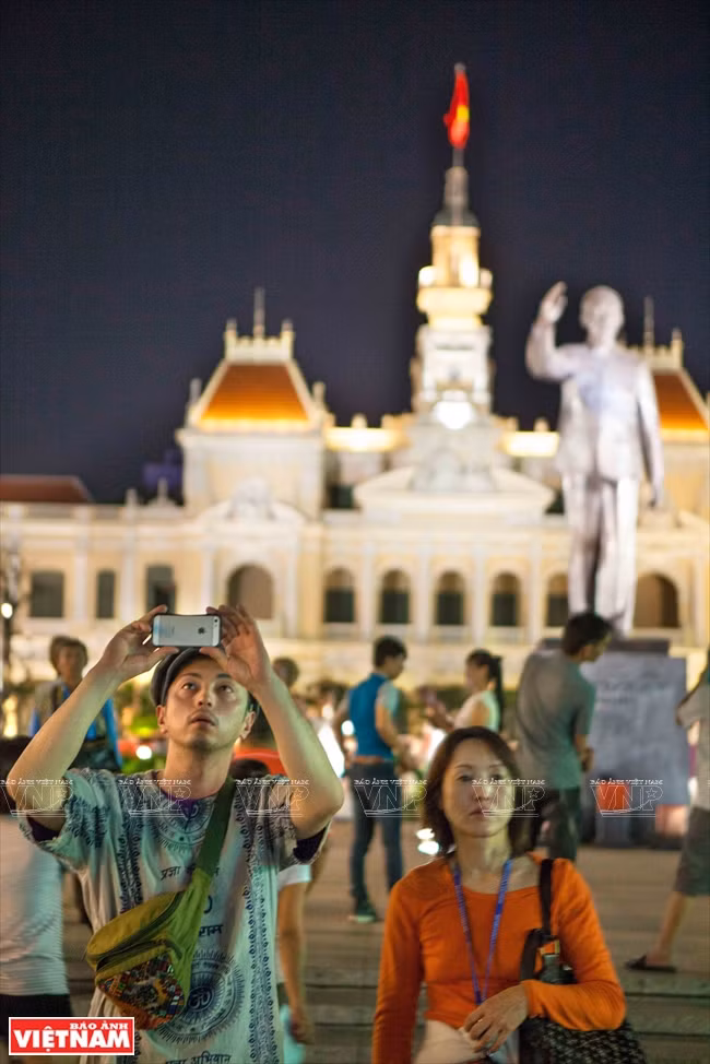 Turistas sudcoreanos sacan fotos de fuegos artificiales en Ciudad Ho Chi Minh (Fuente: VNA)