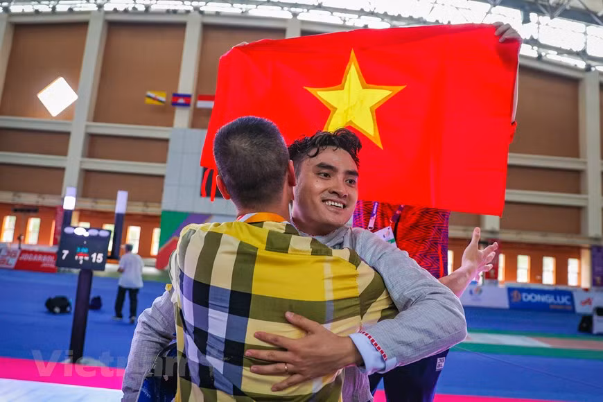 Inmerso en una gran emoción, el entrenador Pham Anh Tuan abraza a Vu Thanh An después de ganar la primera medalla de oro para la selección de esgrima de Vietnam en los SEA Games 31. Al intercambiar con la Agencia Vietnamita de Noticias, el entrenador en jefe Pham Anh Tuan dijo que con la capacidad actual del equipo nacional de esgrima, el país puede establecer una meta más alta de ganar cinco oros en este deporte de los SEA Games 31. Al participar en SEA Games 31, los deportistas vietnamitas apuntan a ganar 140 medallas de oro, 77 de plata y 71 de bronce en la cita deportiva regional, que se organiza cada dos años con la participación de miles atletas procedentes de 11 países del Sudeste Asiático (Foto: Vietnam+)