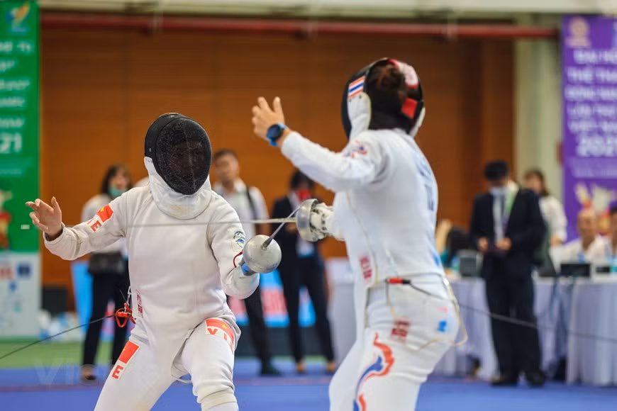 El deportista Vu Thi Hong en el partido contra el tailandés Vasanasomsithi Pacharaporn. Preparándose para los SEA Games 31, la selección de esgrima de Vietnam, con cinco entrenadores y 24 atletas, se reunió desde el 1 de enero de 2022 en el Centro de Entrenamiento y Competición Deportiva de Hanoi. El entrenador en jefe Pham Anh Tuan declaró: "En las tres últimas ediciones de los SEA Games 31, la selección de esgrima de Vietnam ha obtenido muchos éxitos. En los SEA Games 2015, ganó ocho medallas de oro, en los de 2017, tres medallas de oro y en los de 2019, cuatro oros. En los SEA Games 31, nuestro objetivo es lograr de dos a tres medallas de oro"(Foto: Vietnam+)