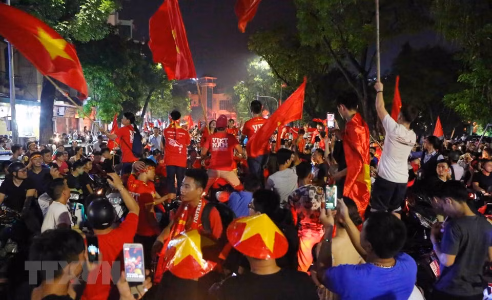 Los hanoienses salen a las calles en las motos, y no olviden traer la bandera nacional. 