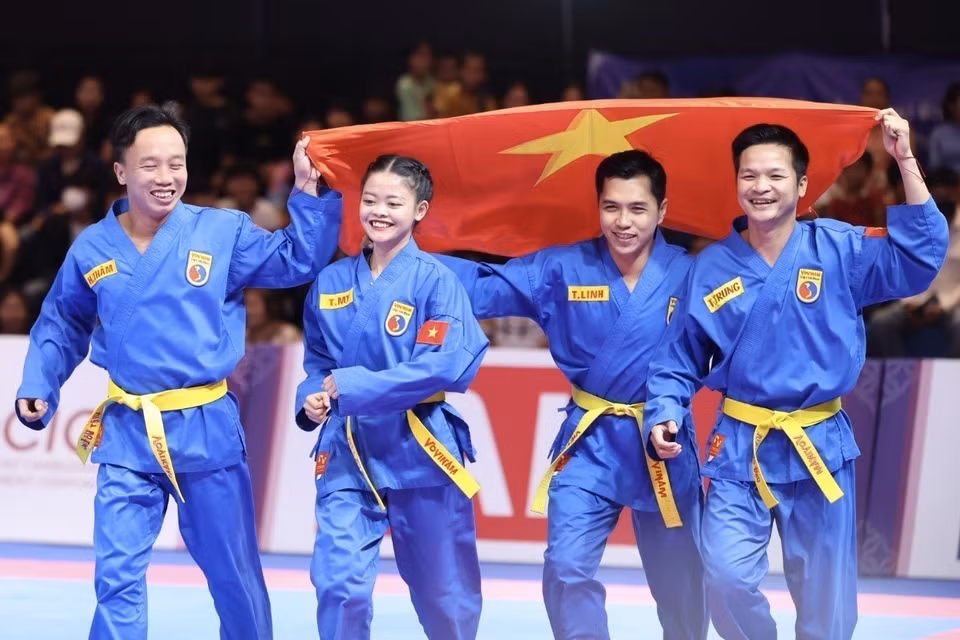 Los atletas Lam Thi Thuy My, Le Toan Trung, Doan Hoang Tham y Lam Tri Linh celebraron su victoria después de ganar una medalla de oro en la disciplina de Vovinam en los SEA Games 32 (Fuente: VNA)