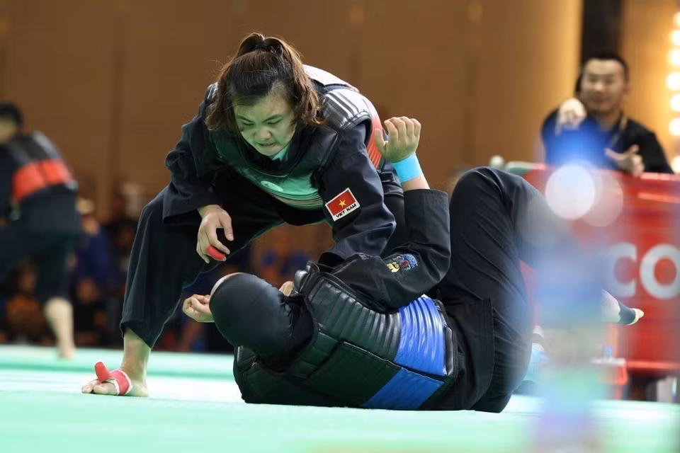 Quang Thi Thu Nghia, (cinturón rojo, derecha) derrotó a Nia Larasati de Indonesia (cinturón azul) en la ronda final de Pencak Silat, en la categoría de lucha de 65-70 kg, para llevar una presea dorada a la selección vietnamita (Fuente: VNA)