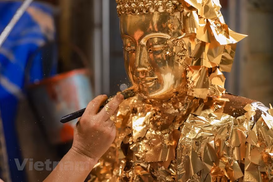 Como la mayoría de los templos, iglesias grandes y pequeñas en todas las regiones del país tienen estatuas u objetos de adoración de Son Dong, los trabajadores aquí siempre están orgullosos. Se trata de estatuas budistas para adorar en las pagodas, de los genios comunales para templos y otras creaciones populares como el dios de la tierra, el dios de la cocina, el dios de la montaña y la diosa del fuego hogareño. La técnica de pintar la estatua es muy elaborada y meticulosa, pasando por muchas etapas para hacer que la superficie sea plana, suave y suculenta. Dependiendo de las necesidades del cliente, en la etapa final el trabajador pegará plata u oro. (Foto: Vietnam+)