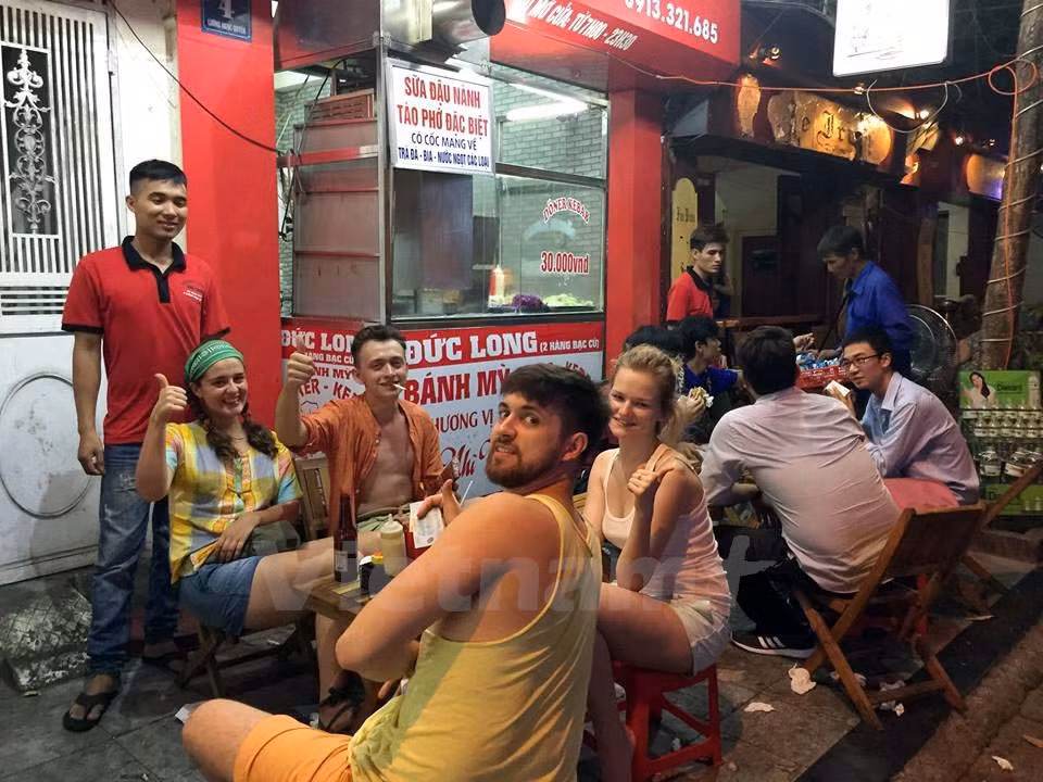 Siempre hay clientes esperando para un Banh Mi de Duc Long – tienda ubicada en la atestada calle Luong Ngoc Quyen 