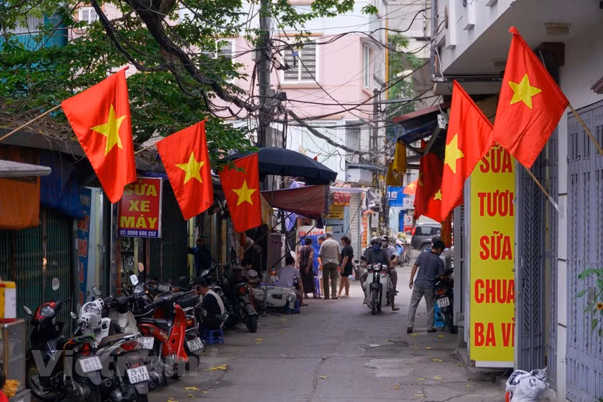 En los barrios en Hanoi, se alzan las banderas de Vietnam, sobresalidas por su color rojo vívido y la estrella amarilla colocada en el centro. Los vietnamitas celebran en estos días dos grandes efemérides del Aniversario 46 del Día de Liberación del Sur y Reunificación Nacional (30 de abril). La Ofensiva General de la Primavera de 1975, cuyo apogeo fue la histórica Campaña Ho Chi Minh, concluyó la larga resistencia contra los invasores estadounidenses y completó la liberación del Sur hacia la reunificación nacional. Desde ese momento, Vietnam logró la soberanía e independencia definitiva después de varias décadas de lucha contra agresores extranjeros. (Foto: Vietnamplus) 