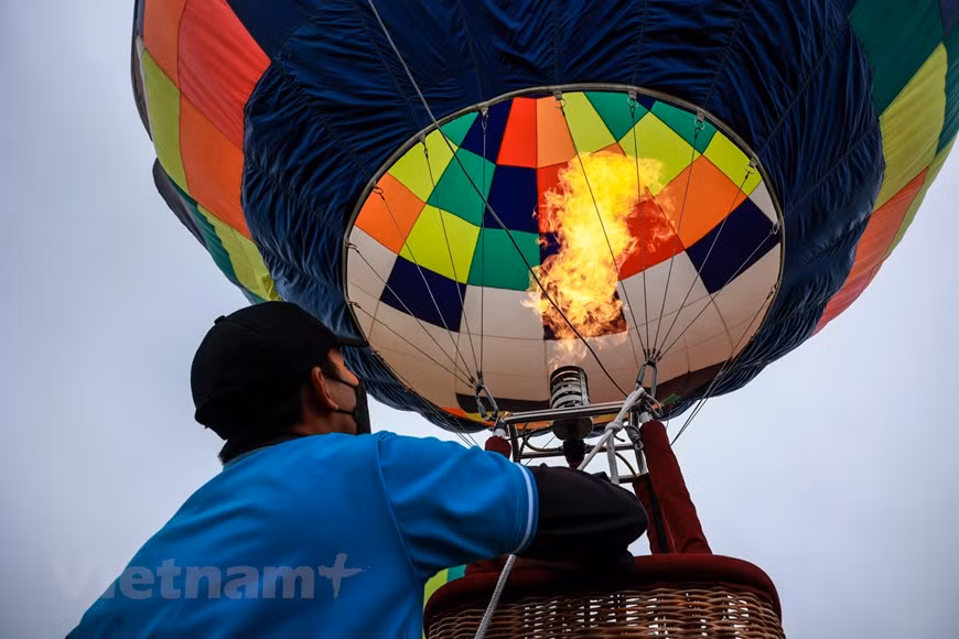 El festival de globos aerostáticos en la capital Hanoi vende entradas a partir del 26 de marzo. La entrada cuesta 60 mil VND por persona (un dólar equivalente a 23 mil VND), mientras los niños menores de 1,1 metros entran gratis. El vuelo en globo cuesta 150 mil VND por niño y 300 mil VND por adulto. El evento atrajo un gran número de visitantes de la capital, quienes se hicieron presentes desde temprano para admirar los coloridos globos aerostáticos. Los jóvenes dijeron con entusiasmo que esta es una oportunidad para que vean y experimenten el nuevo modelo turístico único de la capital. (Foto: Vietnam+) 