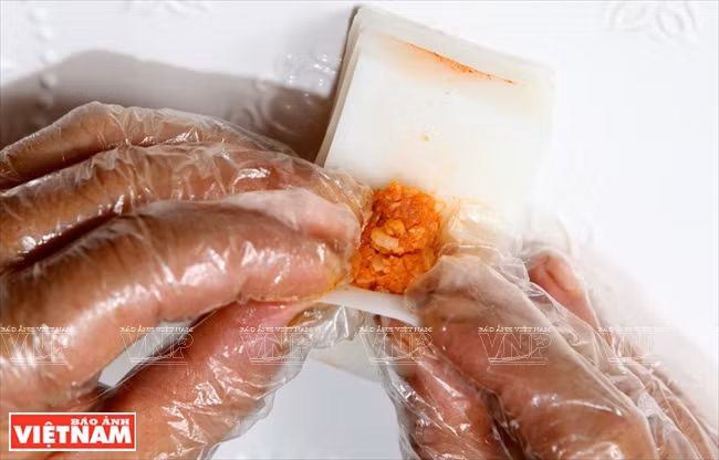 La masa se envuelve con las hojas de fideo de arroz. 
