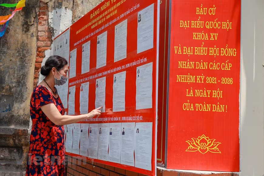 Los votantes están monitoreando la lista de candidatos para la Asamblea Nacional de XV legislatura y los Consejos Populares en todos los niveles para el período 2021-2026. Según lo previsto, más de 69 millones de votantes acudirán a las urnas para elegir a los 500 diputados de la Asamblea Nacional de la XV legislatura y tres mil 726 miembros de los Consejos Populares del mandato 2021-2026. Los trabajos preparativos en los colegios electorales en varios barrios se completaron a finales de marzo de 2021. Mientras, el ambiente de las elecciones nacionales se ha extendido por todas las calles y callejones de la capital. (Foto: Vietnam +) 