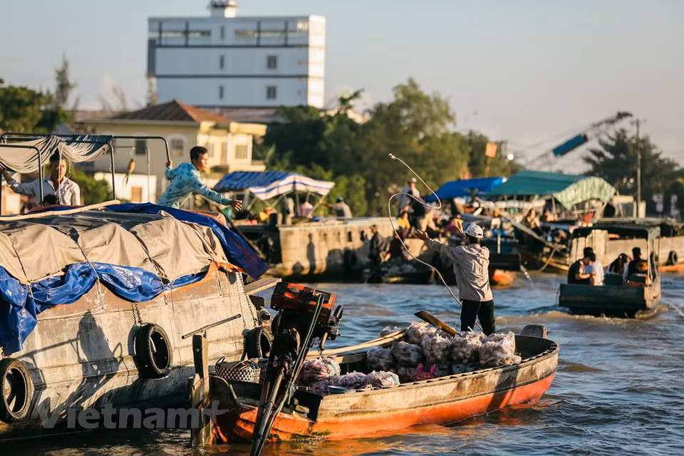 La gente comercia de barco en barco haciendo malabares o pasando artículos con la mano. (Fuente: Vietnam+)