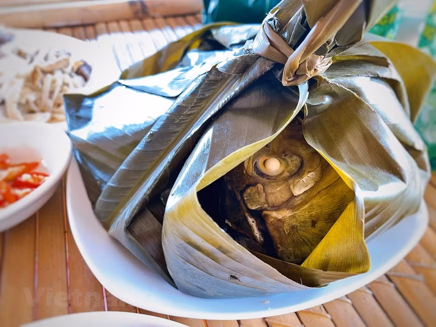 El pescado al vapor también constituye una especialidad de los Muong en la provincia de Hoa Binh. Primero, se limpian los peces pequeños de riachuelo frescos. Luego, se pican el jengibre, el chile y las hierbas, se rellenan en la panza del pescado y se esparcen sobre el cuerpo para marinar. El pescado se envuelve con hojas de “dong” y coloca en una bandeja. El calor se ahuma en el paquete con capas e hojas de dong, desprendiendo un aroma muy atractivo. La dulzura del pescado se derrite en la punta de la lengua mezclada con el aroma de las especias, haciendo que todos inhalen. (Foto: Vietnam +) 