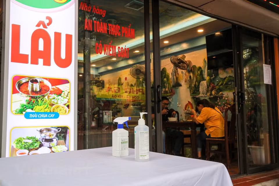 Por la mañana del 19 de agosto en Hanoi, todos los restaurantes y cafeterías siguen estrictamente la dirección de las autoridades municipales sobre la prevención y la lucha contra la pandemia de COVID-19. Se trata de una epidemia ocasionada por el virus coronavirus 2 del síndrome respiratorio agudo grave (SARS-CoV-2). Se identificó por primera vez en diciembre de 2019 en la ciudad de Wuhan, capital de la provincia de Hubei, en China, al reportarse casos de un grupo de personas enfermas con un tipo de neumonía desconocida. Los afectados tenían vinculación con ló trabajadores del Mercado Mayorista de Mariscos del Sur de China de Wuhan. La Organización Mundial de la Salud (OMS) la reconoció como una pandemia global el 11 de marzo de 2020. (Foto: Minh Son/Vietnam +)