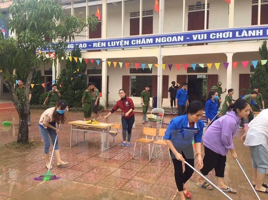 Los militares y el personal de la escuela primaria de Vo Liet, en el distrito de Thang Cuong, limpian el sitio tan pronto como el nivel de agua baja (Foto: VNA)