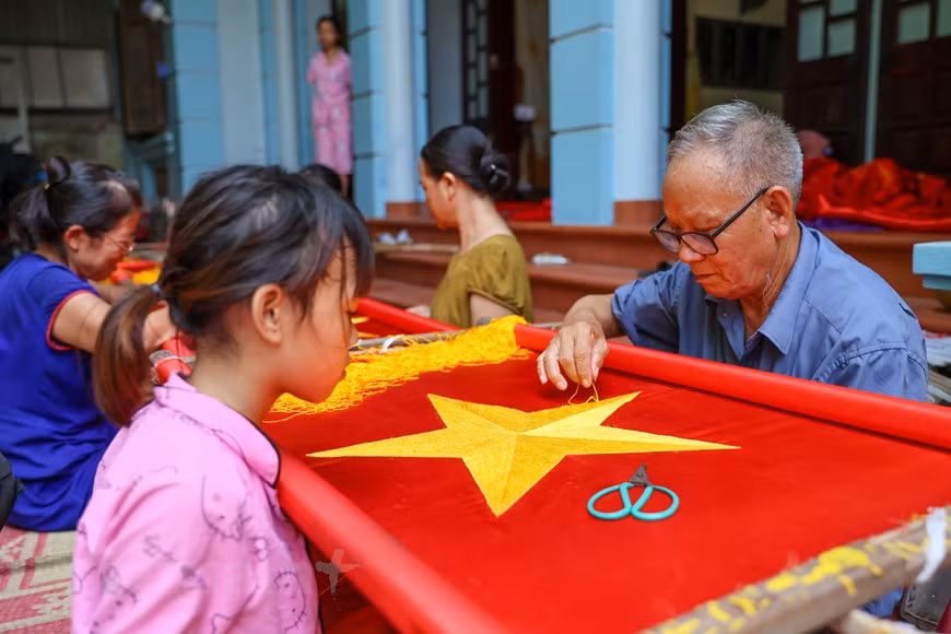 Vuong Thi Nhung cumple 46 años este año pero lleva más de 30 especializándose en el bordado de la bandera nacional. La artesana reveló que su familia ha preservado el oficio durante tres generaciones. Su padre tuvo que aprender el proceso de elaboración de la bandera nacional para poder enseñar a sus hijos y nietos. “En el pasado, todos los días mi papá llevaba las banderas en la bicicleta a la calle Hang Bong, en el distrito de Hoan Kiem, Hanoi, y se las entregaba a los clientes, tenía 94 años pero recorría varias decenas de kilómetros para entregar los productos. El hombre, ahora con 104 años, también fue uno de los primeros artesanos en traer la profesión a la aldea”, comentó Nhung con orgullo. (Foto: Vietnam+)
