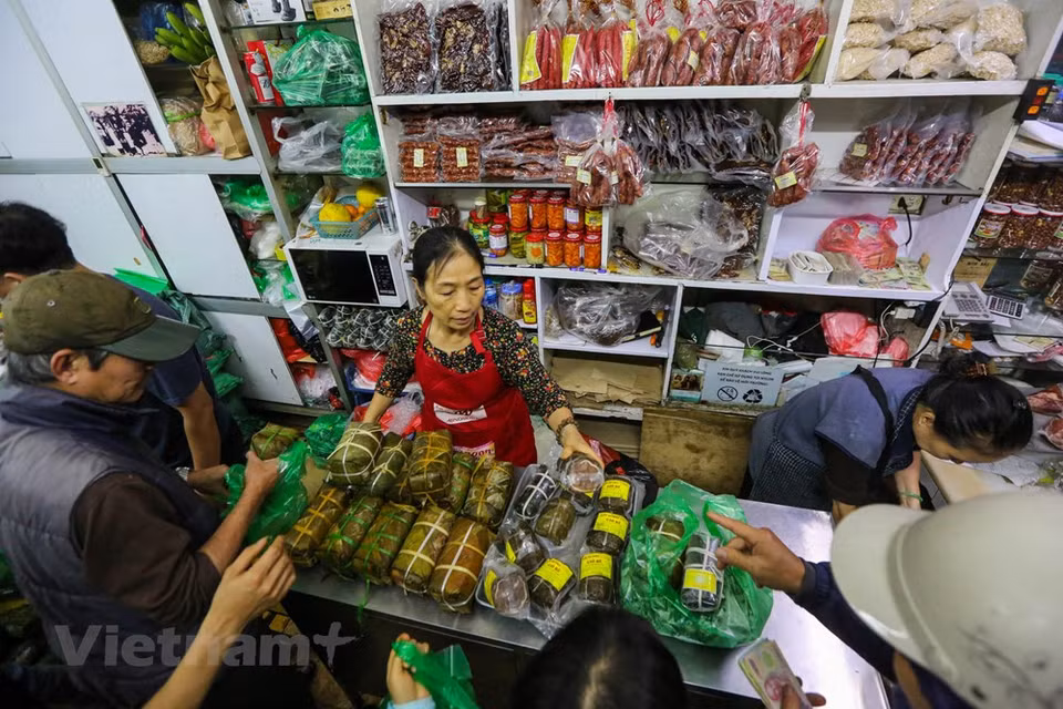 Según los clientes, en este momento del año pasado, muchas personas deben hacer colar y esperar para comprar un par de Banh Chung (pasteles cuadrados de arroz glutinoso, cerdo y guisantes envueltos en hojas de banano) y Gio Cha (jamón o salchicha de Vietnam. Considerado un elemento esencial del altar familiar con motivo del Tet, la elaboración y consumo de Banh Chung durante esa época es una tradición bien conservada por los vietnamitas. También hay variantes de Banh Chung sin cerdo para vegetarianos y budistas, como el Banh Chung Chay o el Banh Chung Ngot. Estas versiones se rellenan con melaza y azúcar morena, y para ellas a veces se mezcla el arroz glutinoso con gac, de forma que el pastel quede con una corteza roja más apetitosa. Fuente: Minh Son/ Vietnam+)