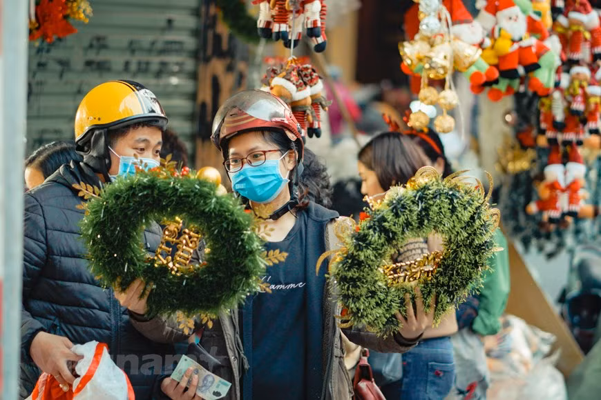 Al pasear por la calle Hang Ma no es difícil encontrar múltiples artículos de decoración de la Navidad, incluidos pinos, coronas de laurel, campanas, copos de nieve y cintas decorativas. La mayoría de esos objetos, de diversos materiales y colores, son hechos en Vietnam con el fin de satisfacer la demanda de los consumidores que ahora prefieren los productos domésticos a los importados. De acuerdo con Nguyen Thanh Hang, dueña de una tienda de souvenirs en la calle de Hang Ma, los precios de los artículos se mantienen estables y los clientes suelen elegir los productos con las marcas comerciales de Vietnam, ya que confían en su calidad. (Foto: Vietnam+)
