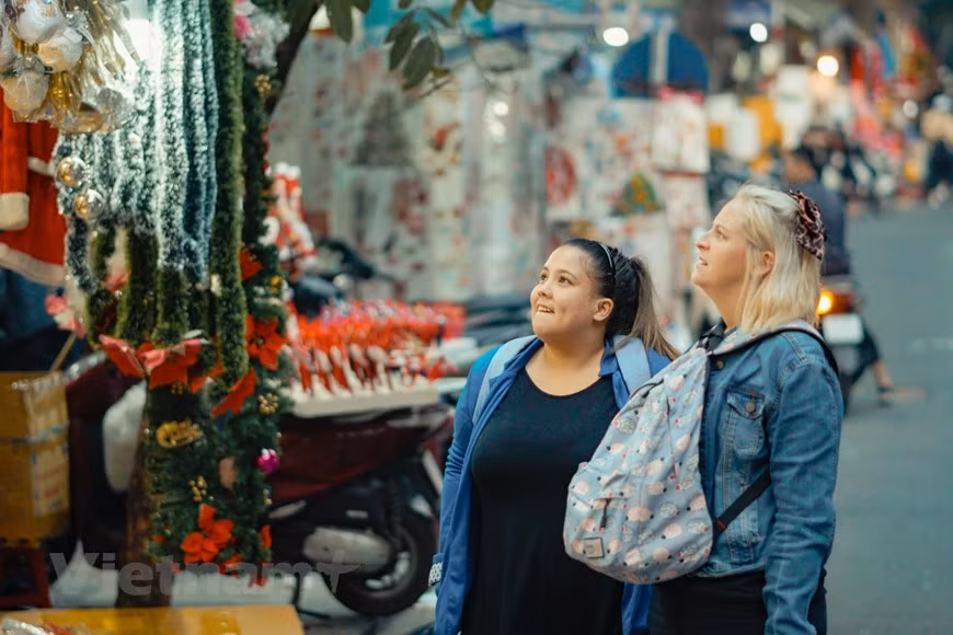 Los turistas extranjeros también aprovechan la ocasión para disfrutar del ambiente navideño de esta calle. La Navidad (en latín: nativitas, ‘nacimiento’) es una de las festividades más importantes del cristianismo, junto con la Pascua de resurrección y Pentecostés. Esta liturgia, que conmemora el nacimiento de Jesucristo en Belén, se celebra el 25 de diciembre en la Iglesia católica, en la Iglesia anglicana, en algunas comunidades protestantes y en la mayoría de las Iglesias ortodoxas. El 25 de diciembre es un día festivo en muchos países celebrado por millones de personas en todo el mundo y también por un gran número de no cristianos. (Foto: Vietnam+)