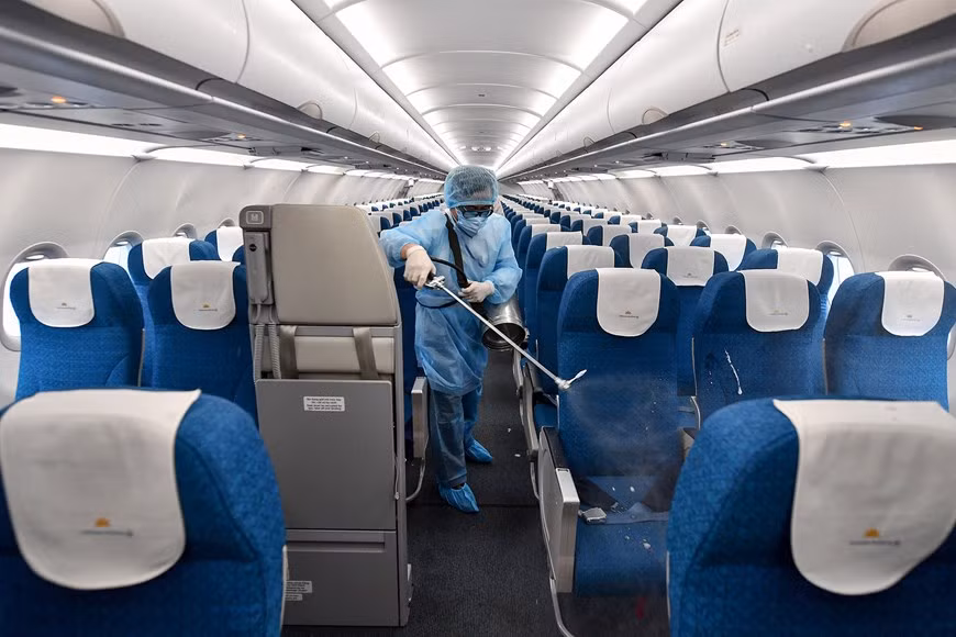 El personal médico rocía desinfectante en todos los asientos y superficie del avión. El avión y los asientos en el interior son un espacio público y los gérmenes pueden sobrevivir en superficies durante mucho tiempo, así que no se pierde nada con limpiarlos. Además de desinfectar tu espacio en el avión, debes lavarte las manos y seguir otras buenas prácticas. Las partículas virales, el vehículo de transmisión del coronavirus, viajan como parte de la mucosa o la saliva, y deben ingresar a través de los ojos, la nariz o la boca. Aunque el coronavirus puede permanecer en objetos de metal, vidrio y plástico hasta nueve días, la aplicación de un desinfectante o de jabón sobre una superficie dura mientras lavas tus manos, matará al virus. (Fuente: Vietnam+)