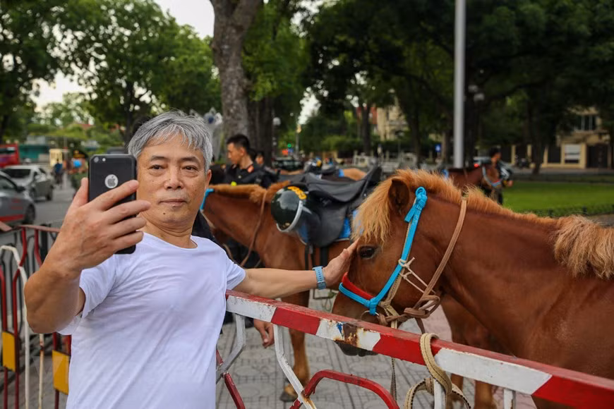 Ya en la madrugada del 8 de junio, un gran número de habitantes de la capital se acercaron al área donde el equipo móvil de la Policía se preparaba para el desfile para tomar fotografías con la caballería. El coronel Nguyen Huy Hanh, jefe de la Fuerza Policial, dijo que la unidad asesoró activamente al Comando de Policía Móvil para organizar el entrenamiento y la formación de bloques para participar en la bienvenida a los líderes del Partido y el Estado. Las fuerzas de seguridad pública están a cargo de coordinar el combate contra la delincuencia, mientras que la guardia fronteriza y el cuerpo aduanero son responsables de prevenir el tráfico de drogas en las zonas limítrofes y los puertos, por lo que no deben realizar esta tarea por separado, señaló. (Foto: Vietnam+)