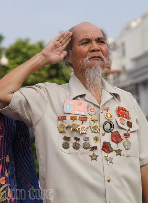 Ngo Xuan Chien, 75, saludó a la bandera nacional. El ex enviado en reconocimiento y experto en armas dijo que, “Agradezco mucho al Partido, al Tío Ho por dar a luz a la República Democrática de Vietnam” (Fuente: VNA)