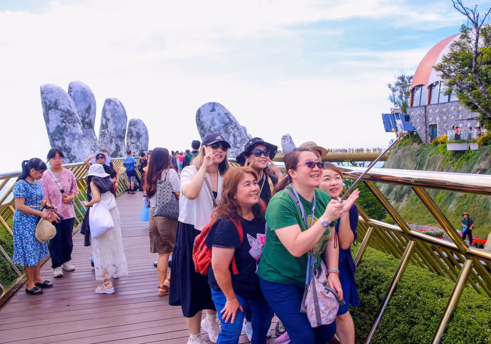Turistas internacionales pasean con entusiasmo por el Puente Dorado, en el área turística Sun World Ba Na Hills. (Foto: VNA)