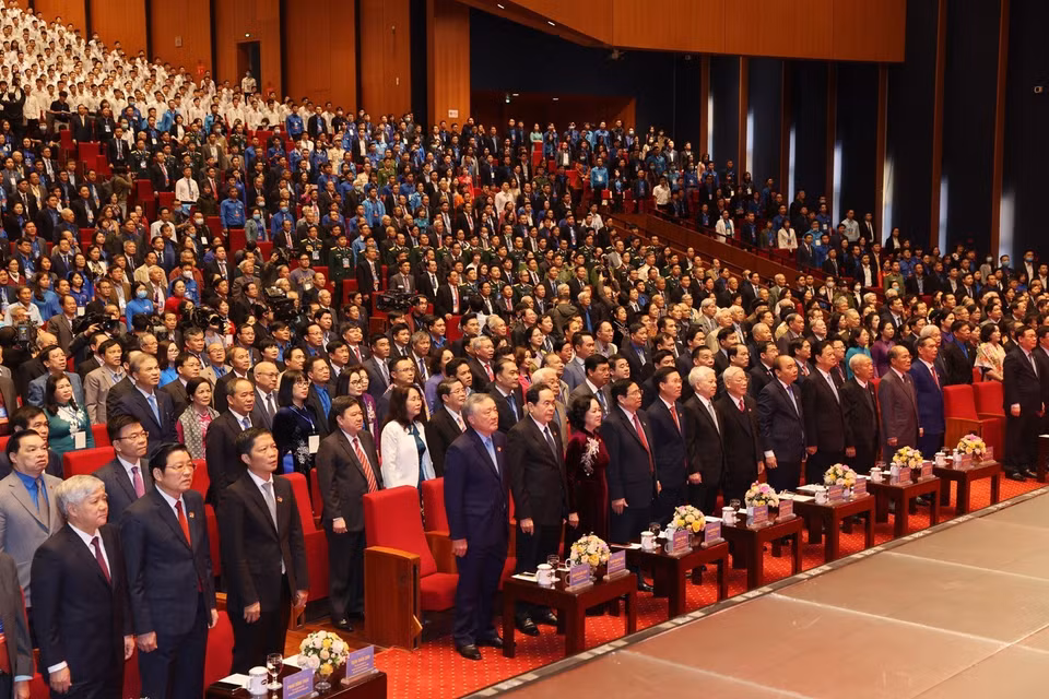 Los delegados participan en la ceremonia de izamiento de la bandera nacional. (Foto: VNA)