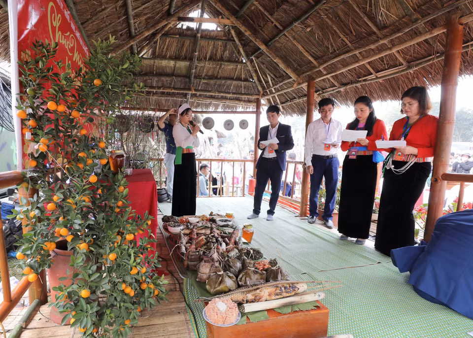 El jurado califica las bandejas de comidas tradicionales de los Muong en el festival. (Foto: VNA)