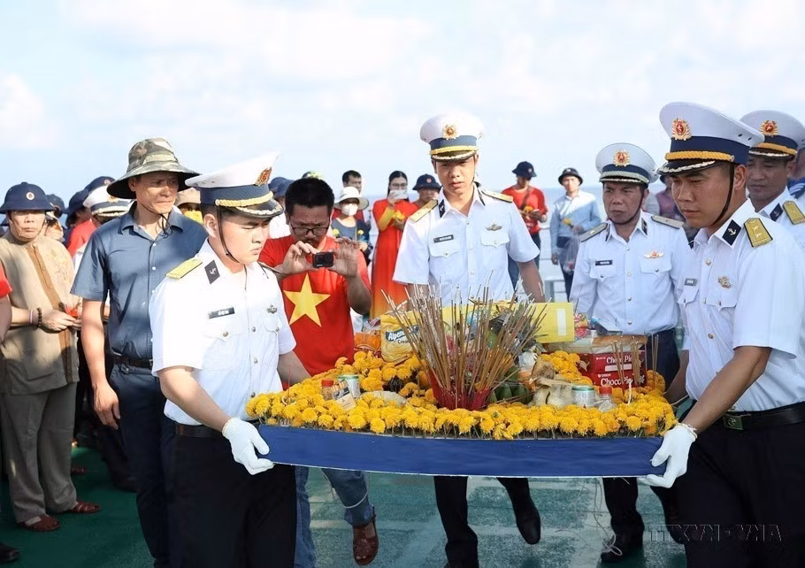 El Grupo de Trabajo 4, que incluye a 47 vietnamitas de ultramar de 22 países y cerca de 200 delegados, ofrece incienso y arroja flores al mar para conmemorar a los oficiales y soldados que fallecieron en Truong Sa. (Foto: VNA)