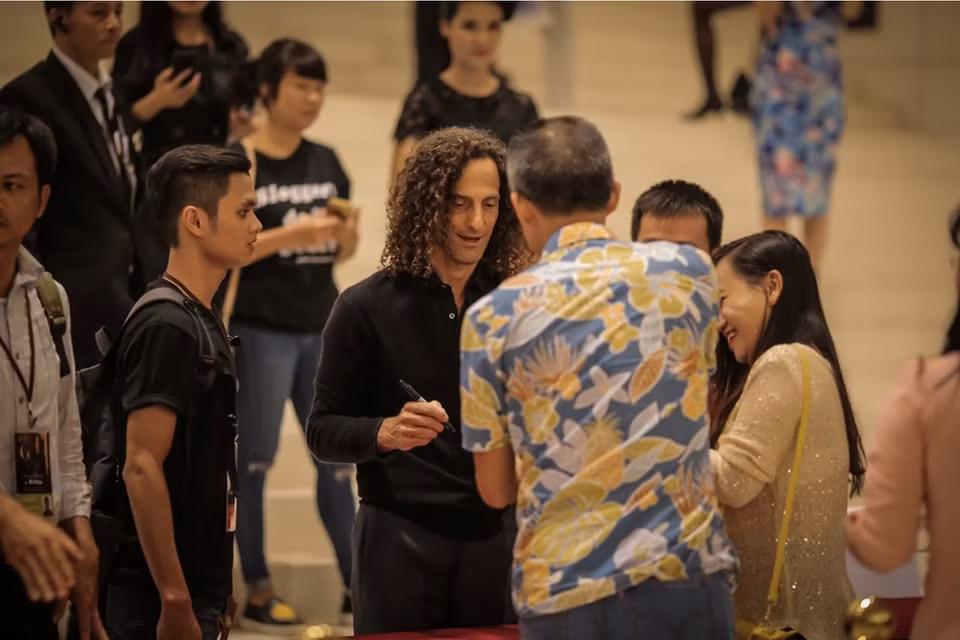 Kenny G regala autógrafo a fanes. 