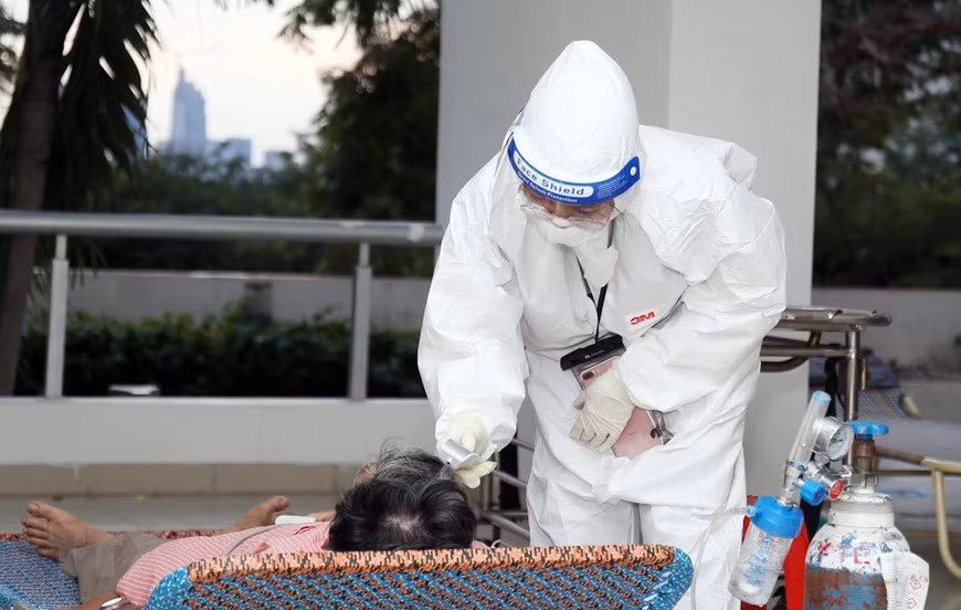 Médico del hospital de campaña número 3 en la ciudad de Thu Duc mide la temperatura de un paciente. (Foto: VNA)