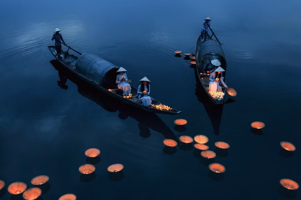 La foto sobre una ceremonia de oración tomada por Bui Phu Khanh captura el momento en el que las mujeres con Ao dai (traje nacional de la mujer vietnamita) y sombreros cónicos arrojan linternas de flores en el río para orar por las almas de los difuntos, así como por la felicidad y la suerte de sus familias. (Fuente: vnexpress.net)