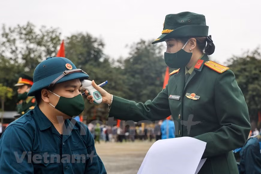 Frente a la situación de la evolución complicada de la pandemia de COVID-19, el Ministerio de Defensa instó que se debe garantizar la seguridad absoluta para la recepción de soldados 2021 con varias normas, por ejemplo no excede a los 20 minutos el tiempo de la realización del evento, mientras que no pueden efectuar las actividades de cultura ni campamentos. Antes de realizar la ceremonia, las agencias y unidades competentes fortalecieron la concientización pública para minimizar el número de la gente de familias que vienen a despedirse, a fin de asegurar el nivel más alto de prevención de COVID-19. A los nuevos soldados se les controla la temperatura por última vez antes de partir hacia el ejército y realizar sus servicios. (Foto: Vietnam+)