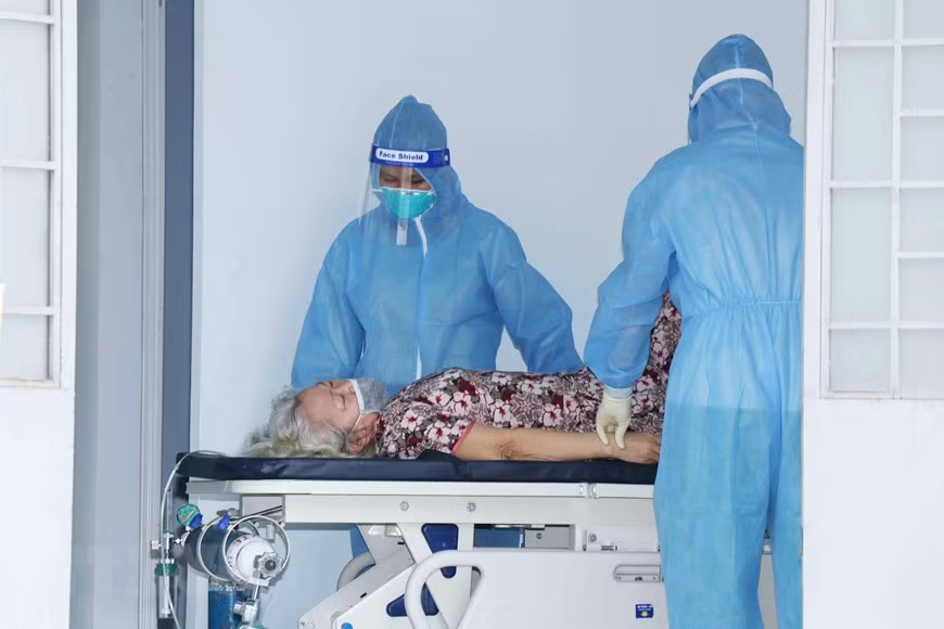 Médicos del hospital de campaña número 4 en la comuna de Vinh Loc B, del distrito de Binh Chanh, atienden a una paciente anciana. (Foto: VNA)