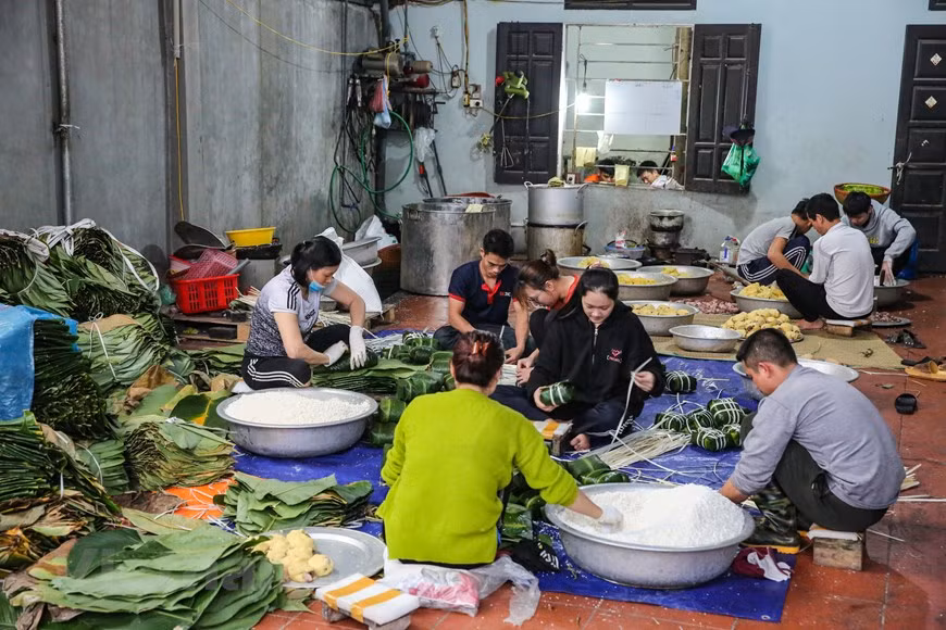 Cada vez que llegan los últimos días del calendario lunar, los vietnamitas alejados de su tierra natal quieren finalizar lo más pronto posible su trabajo para reunirse con su familia y empezar los preparativos del Tet, particularmente la elaboración del Banh chung. En el pasado, las familias solían preparar los ingredientes del Banh chung con dos o tres días de antelación, para que todos los miembros pudieran elaborar los pasteles, de manera conjunta, durante el último día del calendario lunar. Para muchas generaciones, el momento más divertido del Tet era cuando la familia se congregaba alrededor de una gran olla de hierro, colocada por encima del fuego de leña, y esperaba para que los Banh chung se cocinaran por dentro (Foto: Vietnamplus)