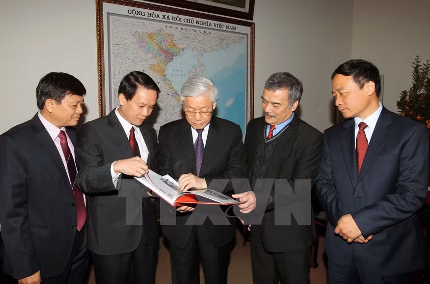 El secretario general del Partido Comunista de Vietnam, Nguyen Phu Trong (C) y dirigentes de la agencia leyeron nuevas publicaciones de la VNA 