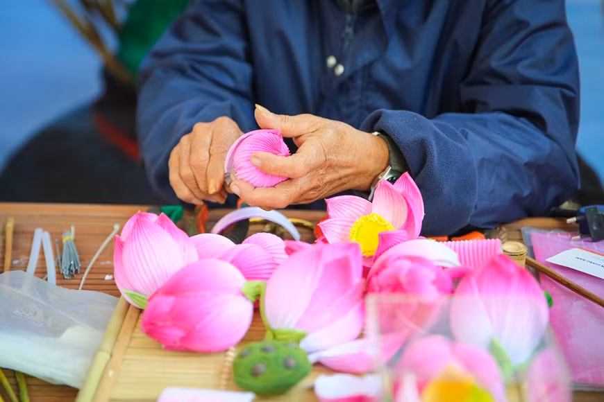 Para satisfacer las necesidades del mercado de flores en ocasión del Tet, los artesanos aquí se ocupan de asegurar la cantidad de productos. Hacer una flor requiere que los artesanos tengan manos hábiles y meticulosas, las etapas para fabricar una incluyen varias etapas: el bambú se corta y se seca; el papel se colorea; las flores se recortan meticulosamente para que cuando se retire el pegamento, se cree una rama de flor que esté en armonía con el color y el diseño. Un artesano de flores de papel experto puede hacer de 15 a 20 flores por día, por lo que tiene que realizar máximos esfuerzos para satisfacer la demanda del mercado. (Foto: Vietnam+)
