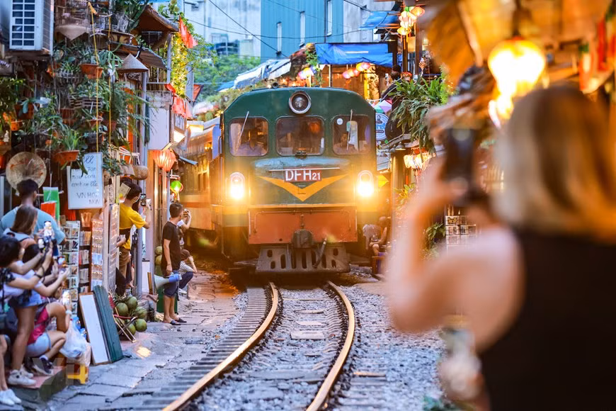 Tras aparecer por primera vez en el diario británico DailyMail en abril de 2014, la calle del tren se ha convertido en un destino atractivo para los turistas en Hanoi. A propósito del creciente número de visitantes, a lo largo de la vía comenzaron a "brotar" muchos cafés. En TripAdvisor, el sitio ocupa actualmente el segundo lugar entre 107 destinos pintorescos en Hanoi. Los visitantes acuden a la vía, tanto de día como de noche, para capturar el momento en que los trenes pasan. Ante el arribo de un tren, los puestos de guardia alertan con 10 minutos de anticipación, para cuidar la seguridad en la vía ferroviaria. (Foto: Vietnam+)