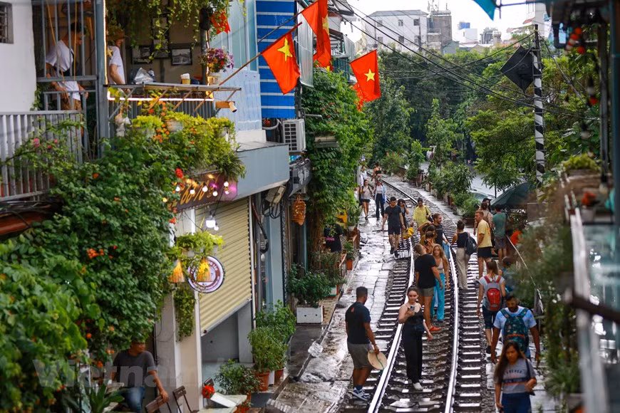 A partir de la fama conquistada en internet, se ha convertido en una costumbre o reto entre los turistas acudir a la calle del tren para tomarse fotos de selfie y publicarlas luego en las redes sociales, disfrutar de un café o una cerveza fría en los establecimientos locales y, al mismo tiempo, apreciar la vida sencilla de los residentes de ese barrio de Hanoi. El lugar constituye una atracción para los visitantes por su entorno vívido y colorido. Actualmente, esta calle especial de la capital vietnamita reanudó sus actividades, pero las tiendas y cafeterías solo pueden ofrecer servicios en la parte interior. Muchos turistas se sientan durante horas a esperar el tren y admirar el entorno estrecho pero animado, capaz de generar una emoción indescriptible. (Foto: Vietnam+)