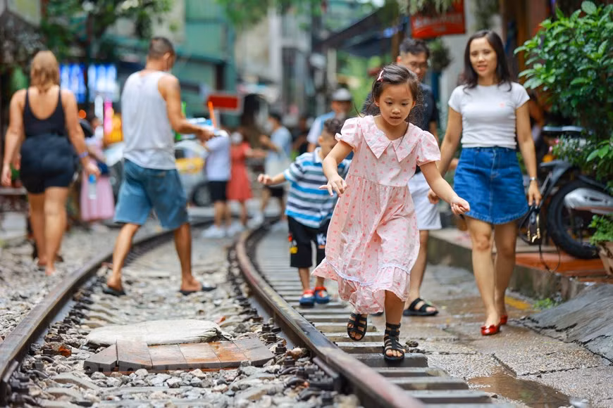 Dos kilómetros de longitud tiene la vía construida por el Departamento General de Ferrocarriles, en 1956, e incluye –a ambos lados- hileras de casas de tejado, apiñadas, que se extienden desde las calles Le Duan y Tran Phu hasta Cua Dong y Phung Hung. Cuando el tren se acerca, el personal de las cafeterías alertará automáticamente al cliente para que salga de la vía en aras de garantizar la seguridad. Sin embargo, debido a que el tren pasa demasiado cerca de las casas, su arribo sigue siendo muy peligroso y se considera alto el riesgo de accidentes. Por tal motivo, se deben tomar precauciones, puesto que el sitio atrae a gran número de turistas cada día. (Foto: Vietnam+)