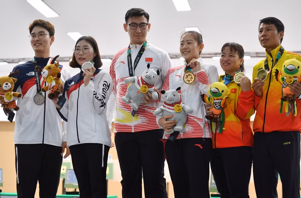  Le Thi Linh Chi y Tran Quoc Cuong ( los dos primeros por la derecha) ganan bronce en 10 metros de pistola 