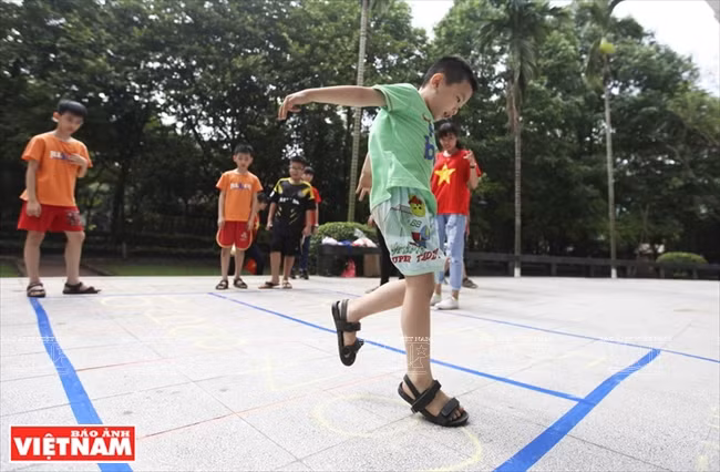 Juego salto a la pata coja (Foto: VNA)