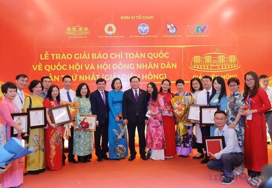 El presidente de la Asamblea Nacional, Vuong Dinh Hue, y la directors general, Vu Viet Trang, se fotografían con los autores y grupos de autores de la VNA que ganaron premios Dien Hong. (Foto: VNA)