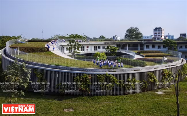 El techo curvado de la escuela va bajando hasta tocar el suelo.