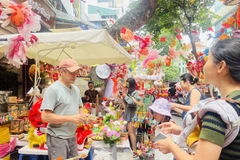 Niños acompañados por sus padres visitan la calle capitalina de Hang Ma para comprar juguetes del Festival de Medio Otoño. Foto: VNA