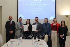 Representantes de ASVI y sus contrapartes en la ceremonia de firma del acuerdo de cooperación. (Foto: VNA)