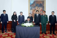 Tran Cam Tu, miembro del Buró Político e integrante permanente del Secretariado del Comité Central del Partido Comunista de Vietnam, escribe en el libro de condolencias por el fallecimiento de Xaysomphone Phomvihane, miembro del Buró Político y presidente de la Asamblea Nacional de Laos. (Foto: VNA)
