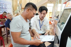 Funcionarios guiando a ciudadanos en la realización de trámites administrativos en la provincia de Quang Ngai. (Foto: VNA)